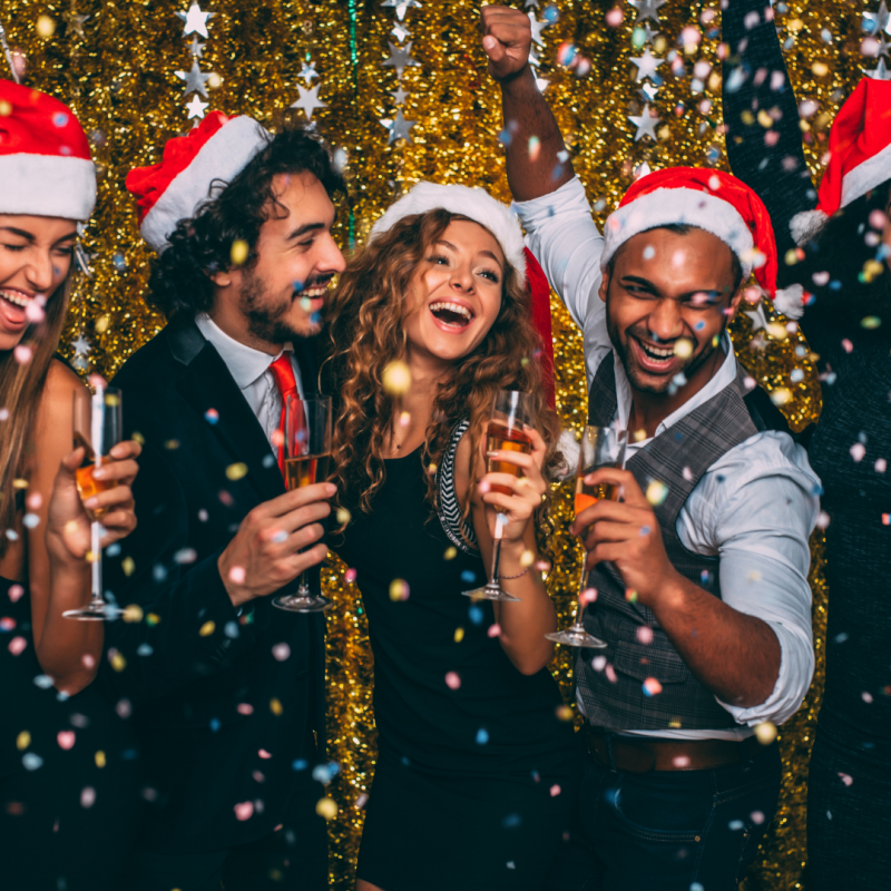 Office Christmas Party Themes people drinking champagne wearing santa hats